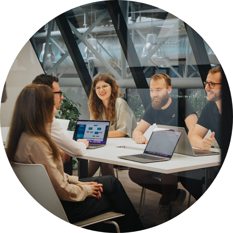 Team sitting at a desk discussing work.